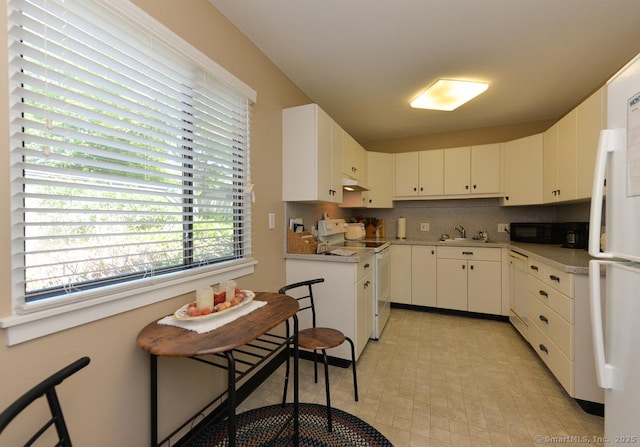 948 Heritage Vlg Unit A, Southbury, CT 06488 - kitchen with white appliances, under cabinet range hood, light countertops, white cabinets, and backsplash