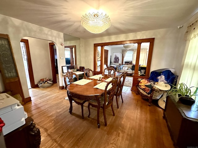 734 Howe Ave, Shelton, CT 06484 - dining space featuring arched walkways, wood finished floors, a chandelier, and plenty of natural light
