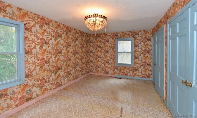 479 Kettletown Rd, Southbury, CT 06488 - empty room featuring wallpapered walls, a chandelier, and light flooring