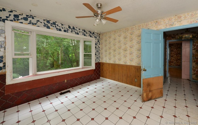 479 Kettletown Rd, Southbury, CT 06488 - unfurnished room featuring tile patterned floors, a wainscoted wall, healthy amount of natural light, ceiling fan, and wallpapered walls