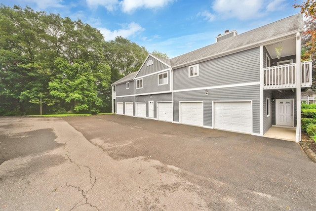 205 Windgate Cir Unit A, Monroe, CT 06468 - view of side of property featuring a chimney, a balcony, driveway, and roof with shingles