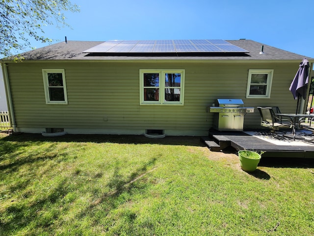 1014 N Worthy St, Windsor, CT 06095 - back of property with a wooden deck, solar panels, a yard, and a shingled roof