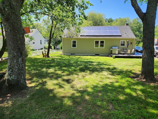 1014 N Worthy St, Windsor, CT 06095 - rear view of house featuring roof mounted solar panels, a chimney, and a deck