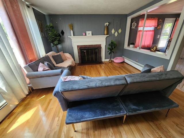 1014 N Worthy St, Windsor, CT 06095 - living room with baseboard heating, wood finished floors, and a brick fireplace