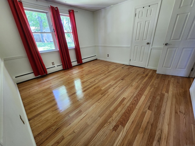 1014 N Worthy St, Windsor, CT 06095 - unfurnished bedroom with light wood-style flooring and a baseboard heating unit