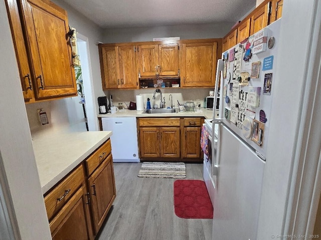 177 Lisle St Apt 5, Torrington, CT 06790 - kitchen with white appliances, brown cabinetry, light countertops, and wood finished floors