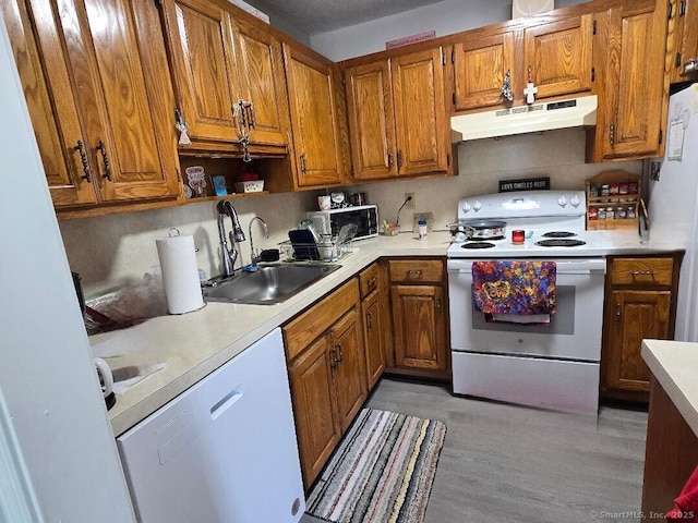 177 Lisle St Apt 5, Torrington, CT 06790 - kitchen featuring under cabinet range hood, white appliances, brown cabinets, and light countertops
