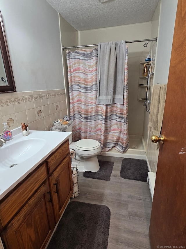 177 Lisle St Apt 5, Torrington, CT 06790 - full bathroom featuring a textured ceiling, vanity, a shower with curtain, wood finished floors, and tile walls