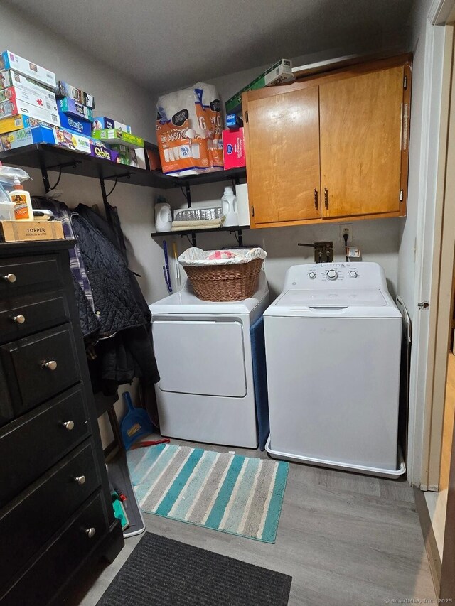 177 Lisle St Apt 5, Torrington, CT 06790 - washroom featuring washing machine and clothes dryer, cabinet space, and wood finished floors