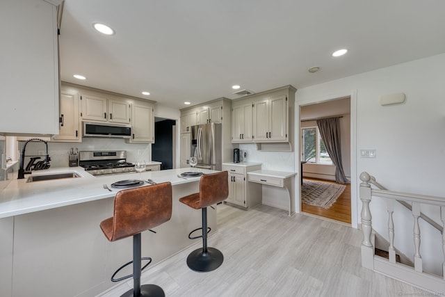 32 Patriot Ln, Newington, CT 06111 - kitchen with appliances with stainless steel finishes, light countertops, a peninsula, a breakfast bar, and recessed lighting