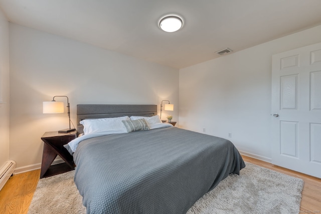 32 Patriot Ln, Newington, CT 06111 - bedroom with light wood-style flooring and a baseboard heating unit