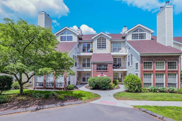 157 Carriage Crossing Ln Unit 157, Middletown, CT 06457 - view of front facade featuring a chimney, brick siding, and roof with shingles