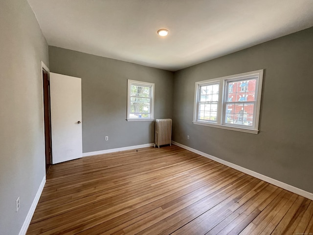 223 S Whitney St, Hartford, CT 06105 - spare room featuring radiator heating unit and wood-type flooring