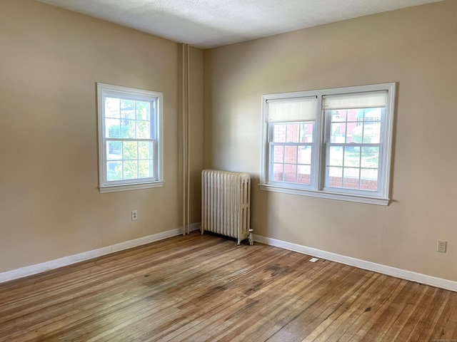 223 S Whitney St, Hartford, CT 06105 - spare room with radiator, wood-type flooring, and a textured ceiling