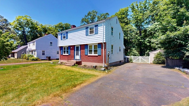 366 Hills St, East Hartford, CT 06118 - colonial inspired home featuring a chimney, driveway, brick siding, and a gate
