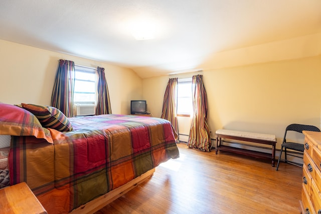 366 Hills St, East Hartford, CT 06118 - bedroom with multiple windows, light wood-style floors, vaulted ceiling, and a baseboard heating unit