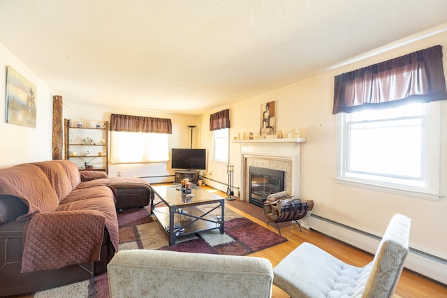 366 Hills St, East Hartford, CT 06118 - living area with healthy amount of natural light, a baseboard heating unit, and wood finished floors