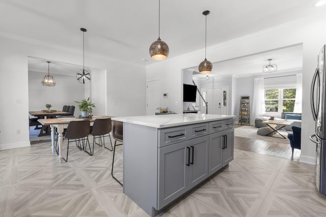 11 Regan Cir, Shelton, CT 06484 - kitchen featuring gray cabinetry, light stone counters, open floor plan, a kitchen island, and ornamental molding