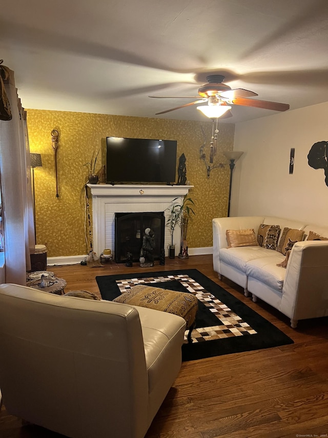 911 Matianuck Ave, Windsor, CT 06095 - living area with wallpapered walls, ceiling fan, wood finished floors, and a fireplace with raised hearth