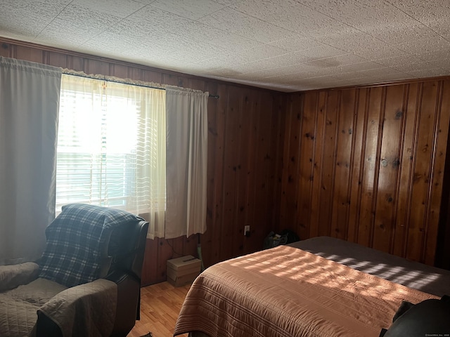 911 Matianuck Ave, Windsor, CT 06095 - bedroom with multiple windows, light wood-type flooring, and wooden walls