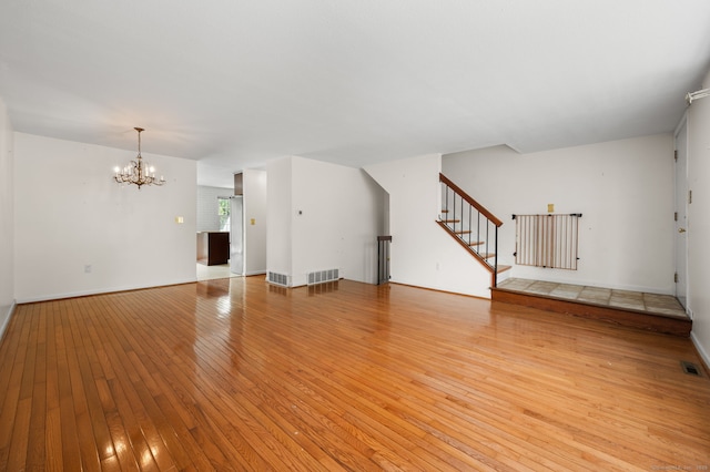 846 Long Hill Rd Unit 846, Middletown, CT 06457 - unfurnished living room featuring a chandelier, stairway, and light wood finished floors