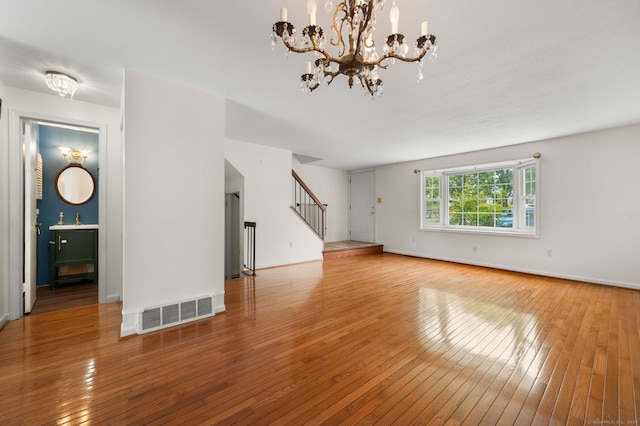 846 Long Hill Rd Unit 846, Middletown, CT 06457 - unfurnished living room featuring wood-type flooring, stairs, and a chandelier