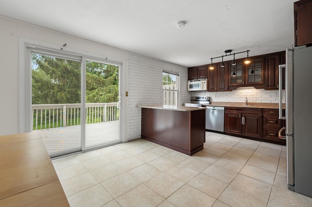 846 Long Hill Rd Unit 846, Middletown, CT 06457 - kitchen featuring appliances with stainless steel finishes, light countertops, dark brown cabinetry, tasteful backsplash, and glass insert cabinets