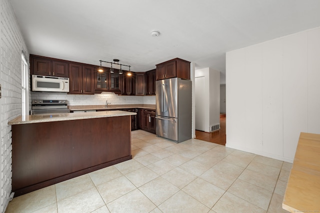 846 Long Hill Rd Unit 846, Middletown, CT 06457 - kitchen with appliances with stainless steel finishes, light stone countertops, dark brown cabinetry, a peninsula, and glass insert cabinets