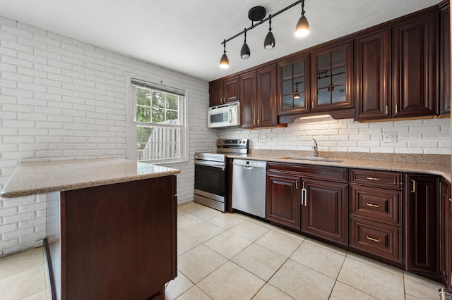 846 Long Hill Rd Unit 846, Middletown, CT 06457 - kitchen featuring stainless steel appliances, light tile patterned floors, brick wall, light stone counters, and glass insert cabinets
