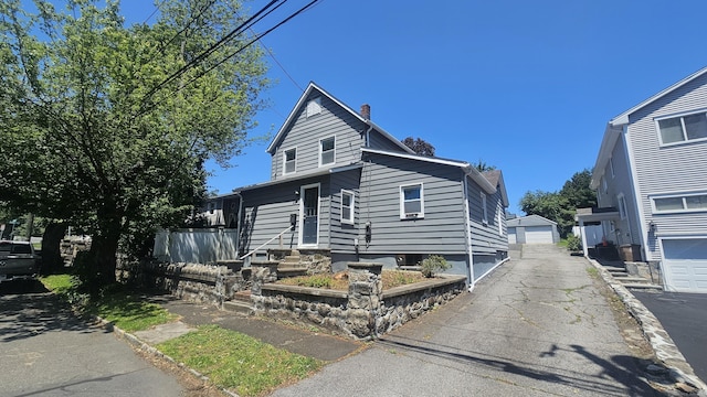 83 Mulberry St, Stamford, CT 06907 - view of front of house with a chimney, entry steps, and a garage