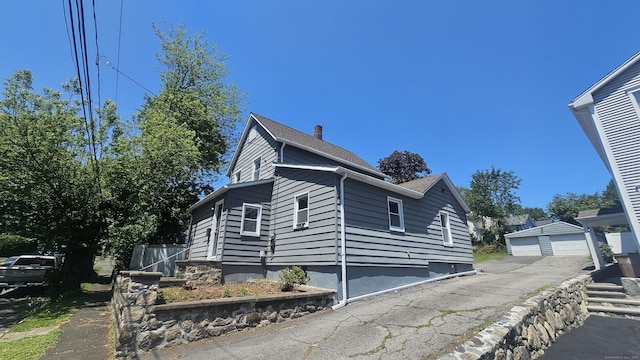 83 Mulberry St, Stamford, CT 06907 - view of side of property with a detached garage and a chimney