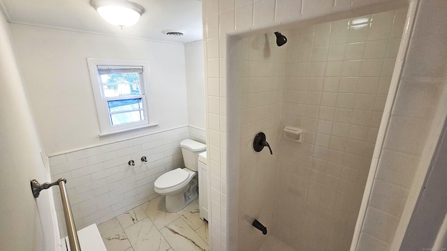 83 Mulberry St, Stamford, CT 06907 - full bathroom featuring marble look tile flooring, a tile shower, tile walls, and wainscoting
