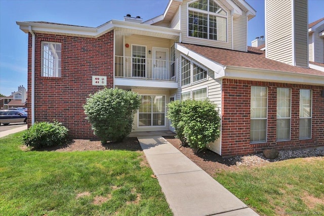49 Carriage Crossing Ln Unit 49, Middletown, CT 06457 - view of front of property featuring brick siding, a balcony, a front lawn, and a chimney