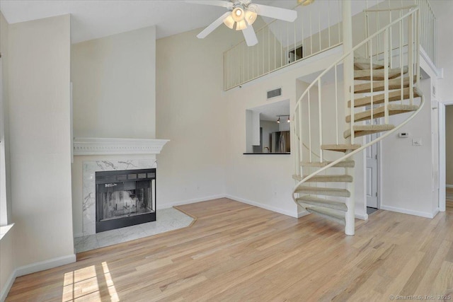 49 Carriage Crossing Ln Unit 49, Middletown, CT 06457 - unfurnished living room featuring wood finished floors, a ceiling fan, high vaulted ceiling, stairs, and a premium fireplace