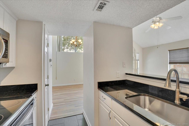 49 Carriage Crossing Ln Unit 49, Middletown, CT 06457 - kitchen with a textured ceiling, tile patterned flooring, white cabinetry, ceiling fan, and a chandelier