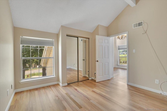 49 Carriage Crossing Ln Unit 49, Middletown, CT 06457 - unfurnished bedroom featuring multiple windows, light wood-style flooring, beam ceiling, a closet, and high vaulted ceiling