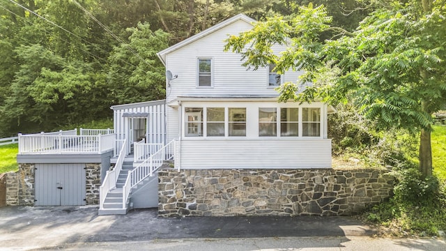 143 Jewett St, Ansonia, CT 06401 - view of front facade featuring a deck, stone siding, a sunroom, and stairway