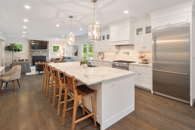 74 Brookside Rd, Darien, CT 06820 - kitchen with high quality appliances, ornamental molding, white cabinetry, tasteful backsplash, and a center island with sink