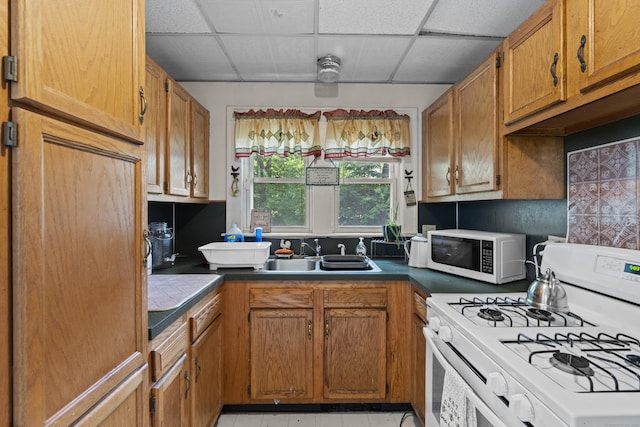 96 Melbourne Ter, Waterbury, CT 06704 - kitchen with white appliances, a drop ceiling, brown cabinets, and dark countertops