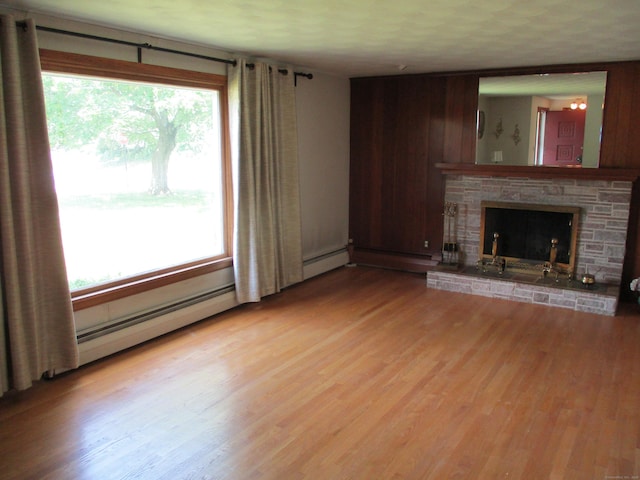 8 Susan Ln, Meriden, CT 06450 - unfurnished living room featuring light wood-type flooring, a fireplace, and wooden walls