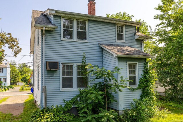 49 Richard Rd, East Hartford, CT 06119 - back of house featuring a chimney, roof with shingles, and a wall unit AC