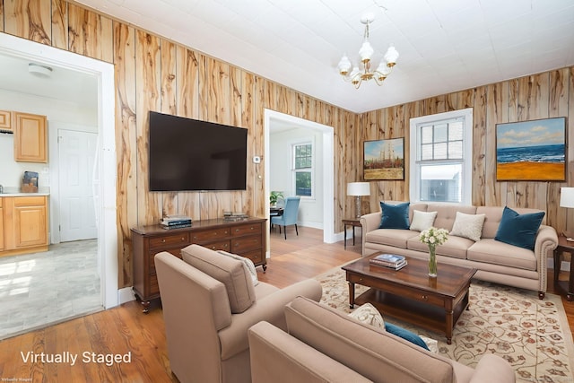 49 Richard Rd, East Hartford, CT 06119 - living area featuring wood walls, a chandelier, light wood-style flooring, and plenty of natural light