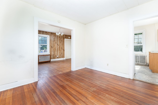 49 Richard Rd, East Hartford, CT 06119 - empty room with radiator heating unit, a chandelier, and wood finished floors