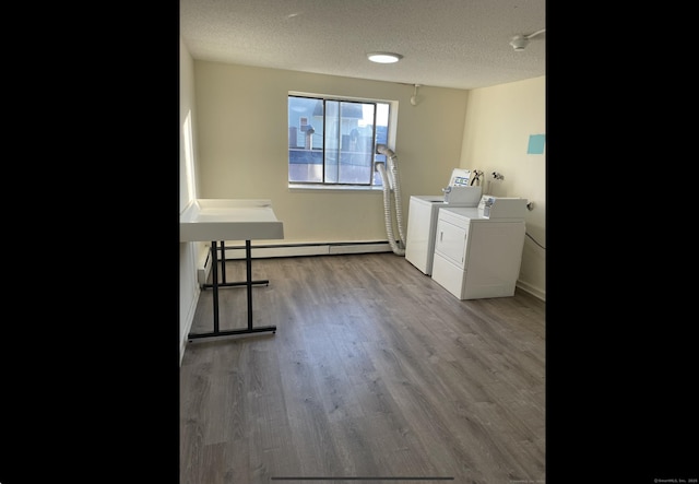 755 Wethersfield Ave Apt A5, Hartford, CT 06114 - laundry room featuring washing machine and clothes dryer, baseboard heating, a textured ceiling, and wood finished floors