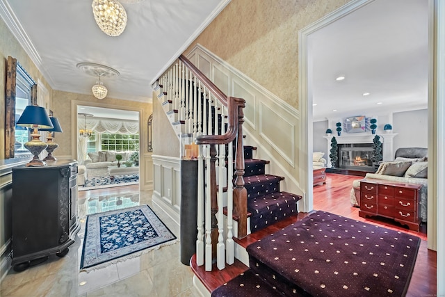 40 Hawley Rd, Danbury, CT 06811 - entrance foyer with a decorative wall, a chandelier, stairway, crown molding, and a glass covered fireplace