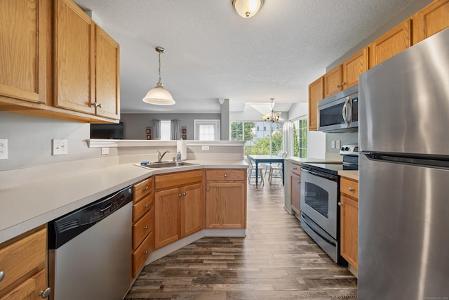 51 Schoolhouse Lndg Unit 51, East Granby, CT 06026 - kitchen featuring appliances with stainless steel finishes, dark wood finished floors, a peninsula, light countertops, and a chandelier