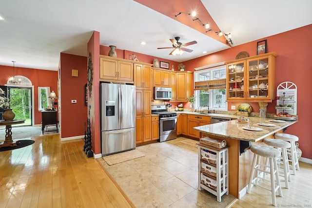 115 Center Rd, Woodstock, CT 06281 - kitchen with stainless steel appliances, a peninsula, light stone countertops, glass insert cabinets, and plenty of natural light