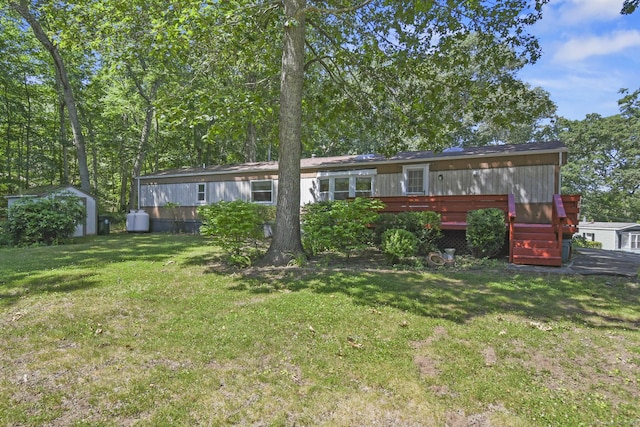28 Nashua St, Norwich, CT 06360 - rear view of house with a storage unit, a lawn, and a wooden deck