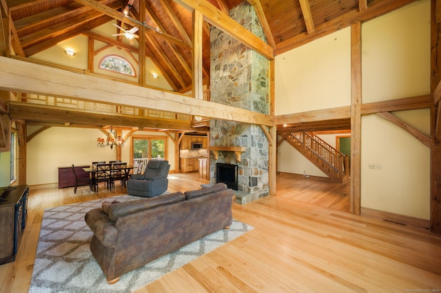 18 Sandpiper Ln, East Lyme, CT 06333 - living area with high vaulted ceiling, stairs, hardwood / wood-style floors, a stone fireplace, and a wood ceiling with exposed beams