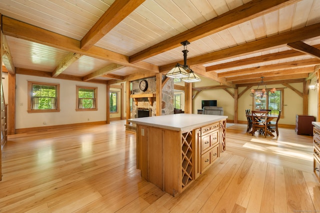 18 Sandpiper Ln, East Lyme, CT 06333 - kitchen featuring open floor plan, light wood-style floors, a fireplace, light countertops, and beam ceiling